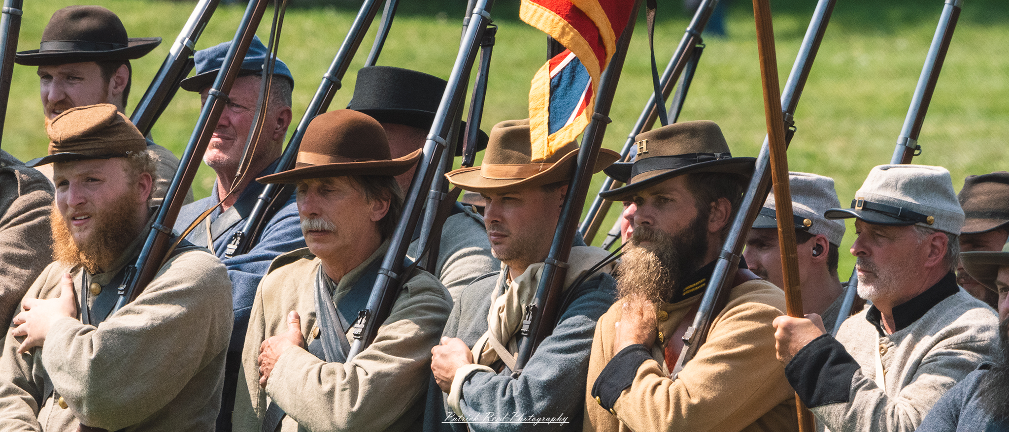 Confederate soldiers standing in ranks, dressed in their gray uniforms with rifles held at the ready. Their expressions are serious and focused, reflecting the unity and discipline of the troops as they prepare for battle, showcasing the strength and resolve of the Confederate forces.